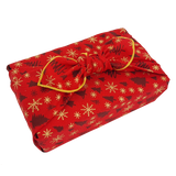 Gift wrapped in a red Christmas print furoshiki with Christmas tree and snowflake detail