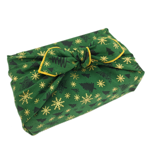 Gift wrapped in a green Christmas print furoshiki with Christmas tree and snowflake detail
