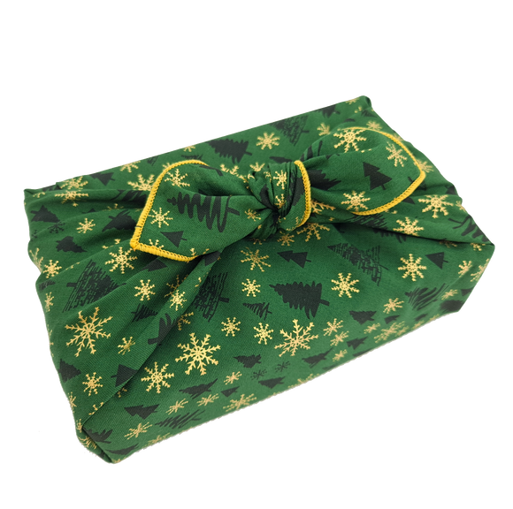Gift wrapped in a green Christmas print furoshiki with Christmas tree and snowflake detail