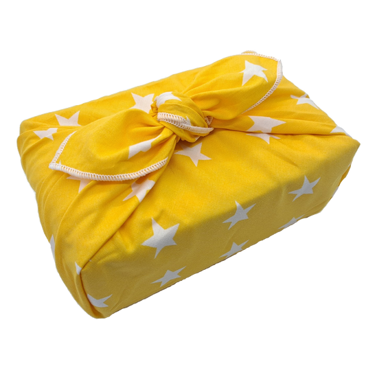 Gift wrapped with a furoshiki that's yellow with white stars