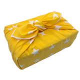Gift wrapped with a furoshiki that's yellow with white stars